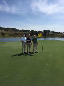 three men on golf course green