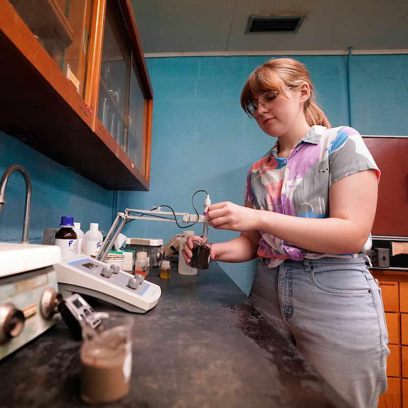 Student in soil characterization lab analyzing soil