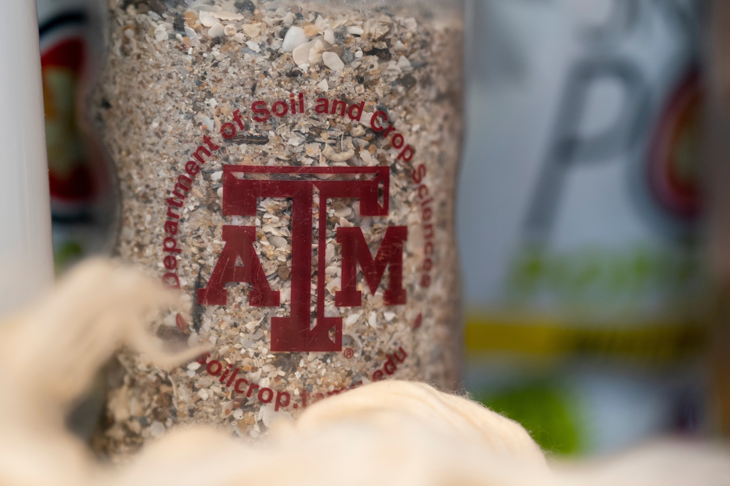 Jar labeled 'department of soil and crop sciences' with soil inside