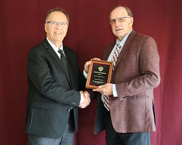 Gary Pastushok standing with David Baltensperger, professor and department head.