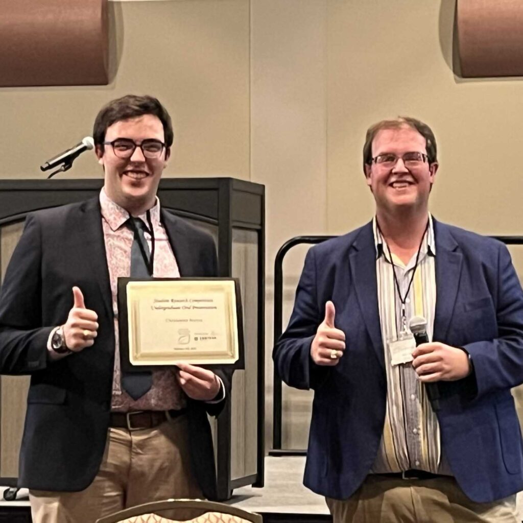 Chris Barron, left, standing with Mason Marshall who is holding a microphone.